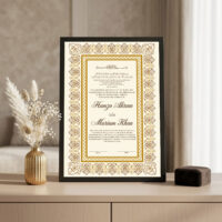 Gold Arabesque Nikkah Frame Black frame on console beside golden vase